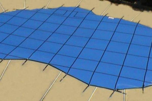 A Garrett pool safety cover over an inground pool