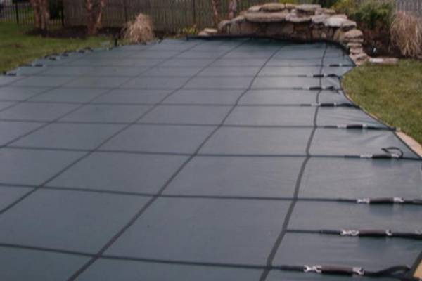 A Garrett pool safety cover over an inground pool