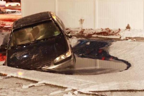 A Garrett pool safety cover holding a car over an inground pool