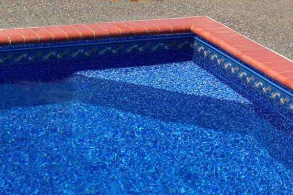 a recently installed in ground pool vinyl liner with ledge