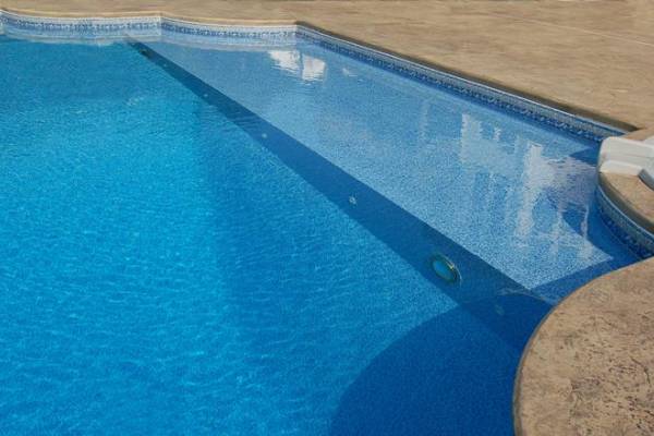 a recently installed in ground pool vinyl liner with ledge