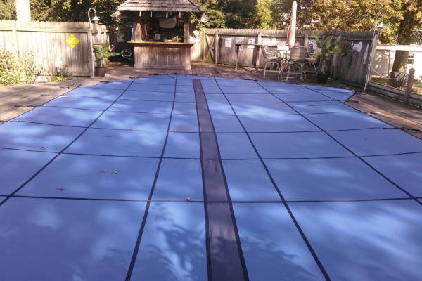 An Garrett pool safety cover over an inground pool - Island Pools Cover Blue US Pitman