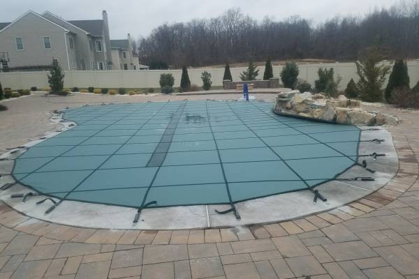 A Garrett pool safety cover over an inground pool